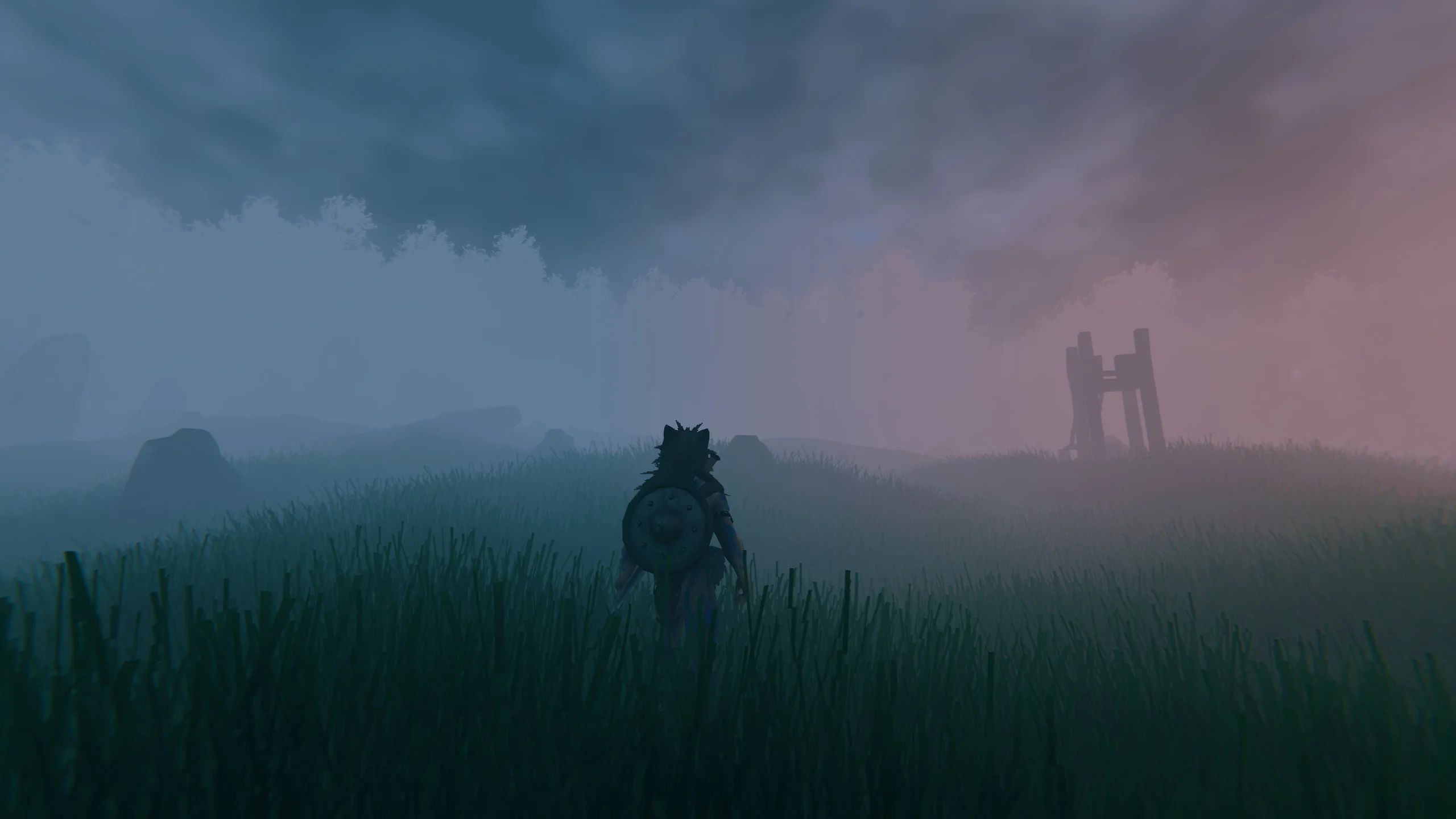 A Viking crossing a mist-covered landscape toward distant ruins